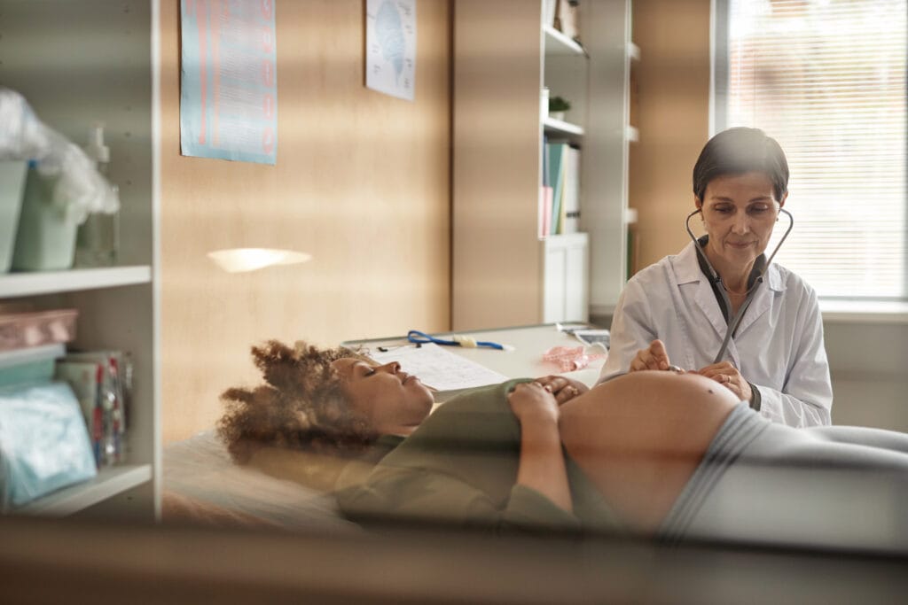 Obstetrician Doing Abdomen Auscultation of Pregnant Patient