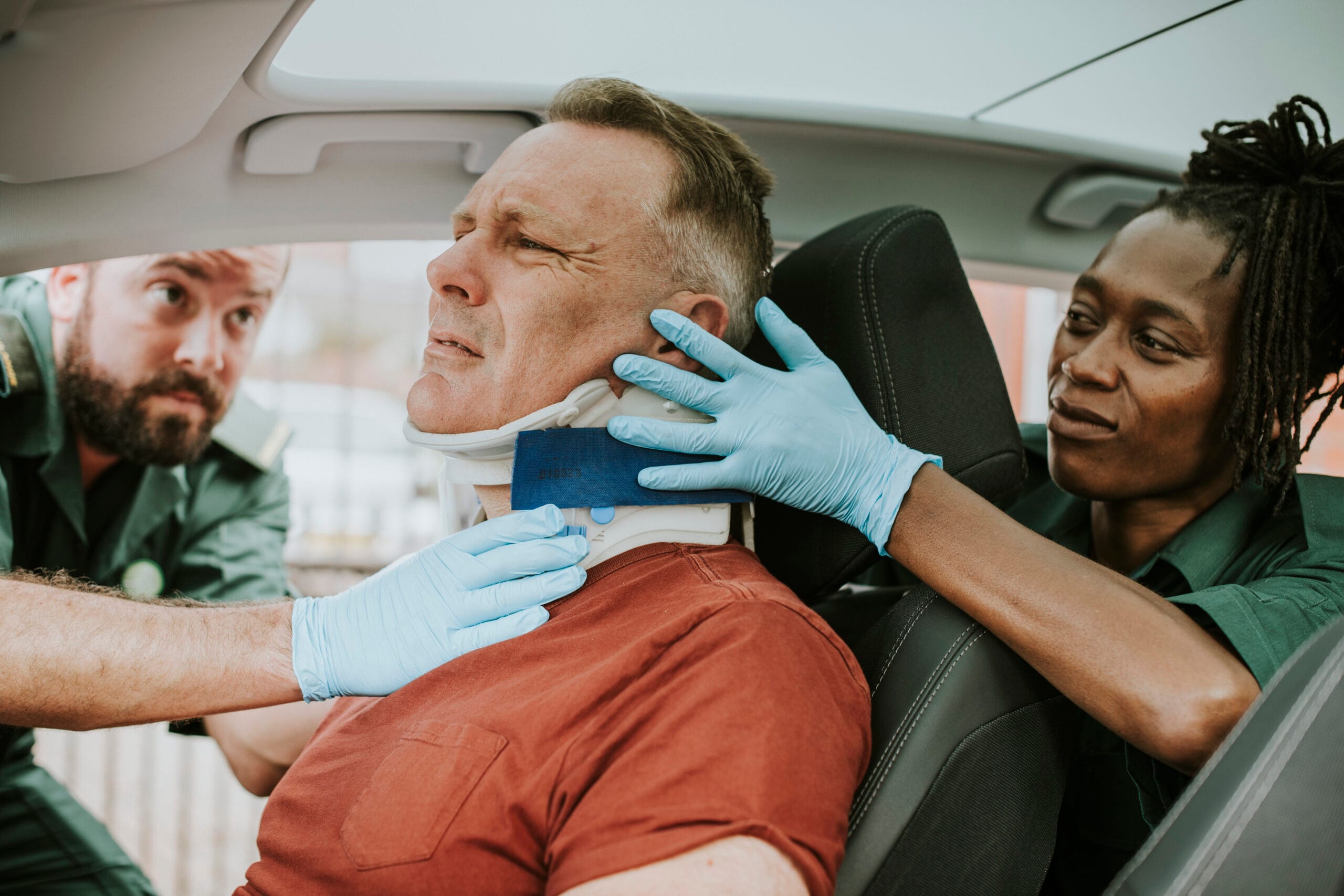 Paramedic placing a cervical collar to an injured man from car accident