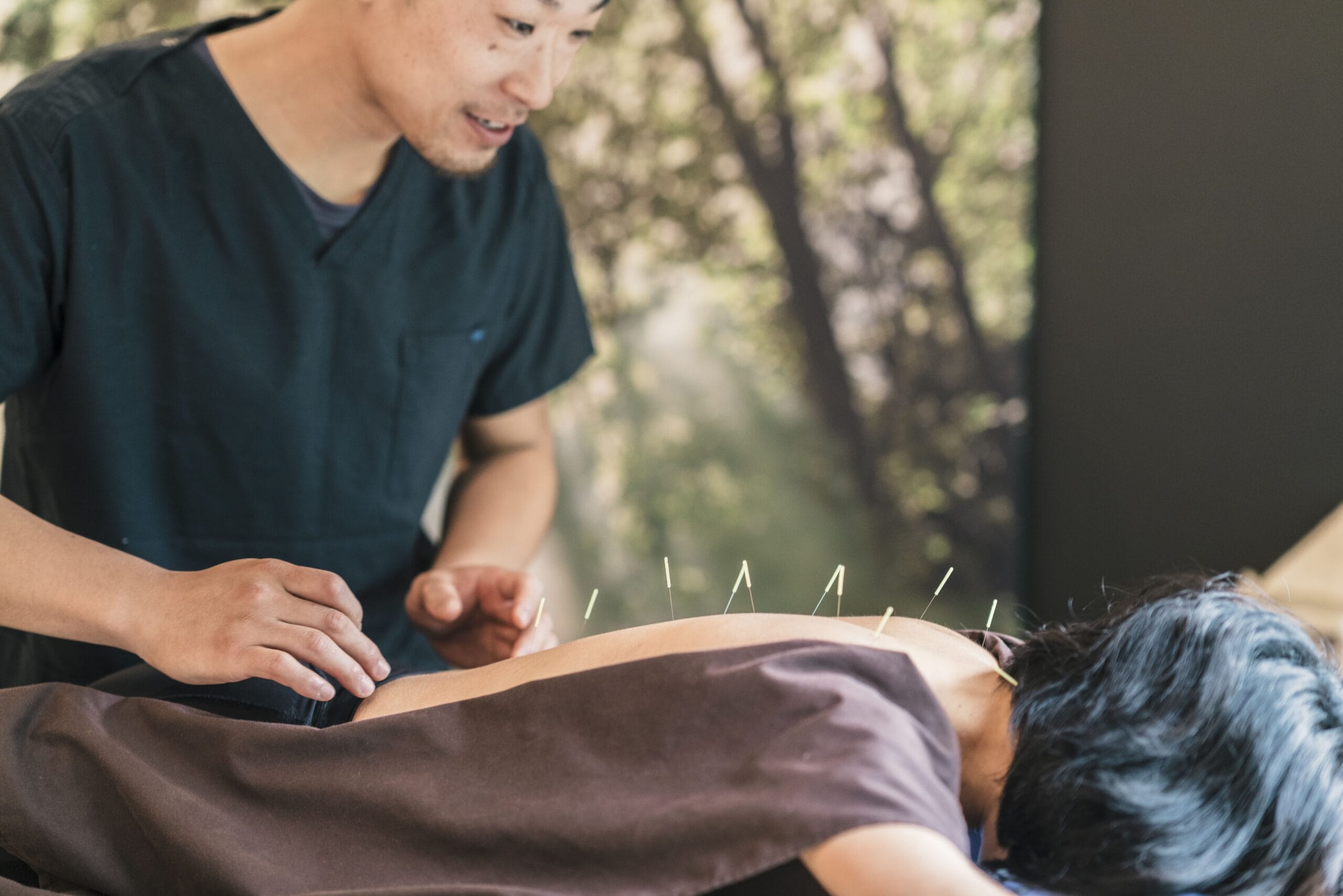 therapist giving cupping treatment to young asian min